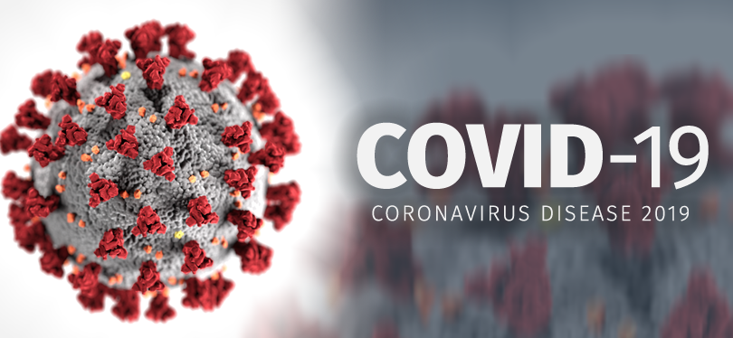 Microscopic illustration of SARS-CoV-2 virus particle with red spike proteins on gray surface.
